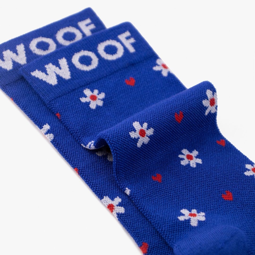 A Floral Bamboo Crew Compression Socks folded neatly to highlight the woven "WOOF" cuff bands and the heart-floral knit pattern layout.